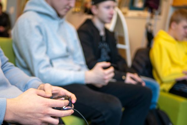 Chilledussa opiskelija peliohjain kädessä ja kolme muuta opiskelijaa seuraa vierestä.