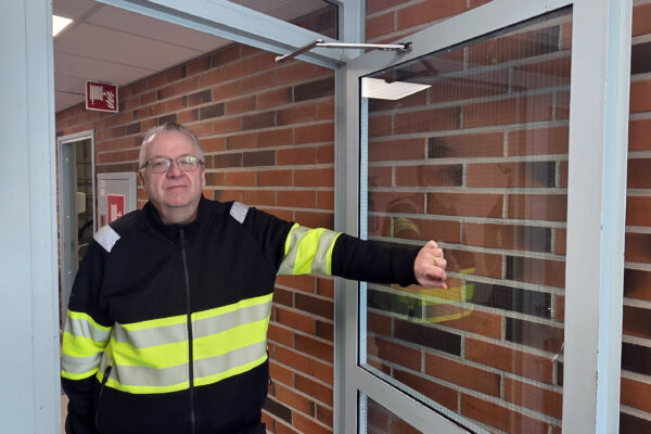 Mies seisoo oviaukossa avatakseen oven